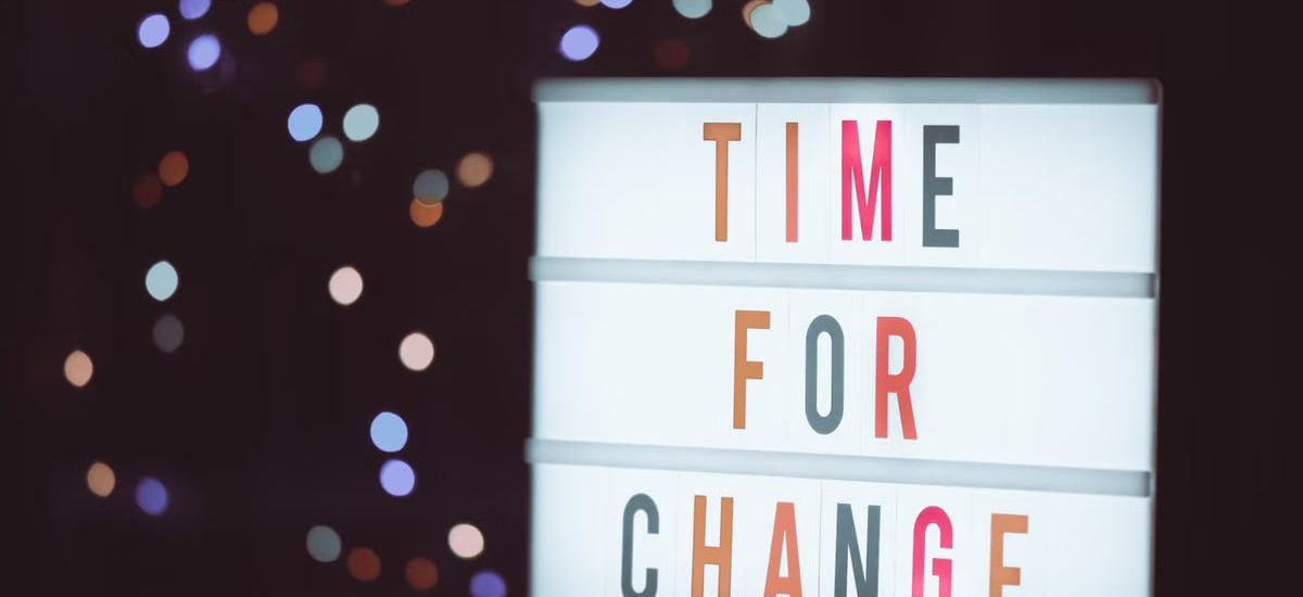 Illuminated lightbox sign displaying 'Time for Change' with a bokeh background, conveying transformation.