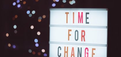 Illuminated lightbox sign displaying 'Time for Change' with a bokeh background, conveying transformation.