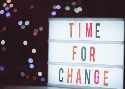 Illuminated lightbox sign displaying 'Time for Change' with a bokeh background, conveying transformation.